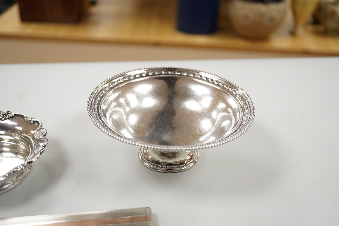 A George V silver pedestal bon bon dish, Sheffield, 1921, diameter 13.2cm, one other earlier silver dish by Josiah Williams & Co, London, 1904 and a silver cigarette case. and a cigarette case, gross 11.5oz.